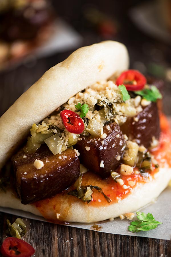 Melt in the mouth savory pork belly stuffed in soft, fluffy mantou with sweet & spicy chili sauce and crunchy sour pickled mustard greens.