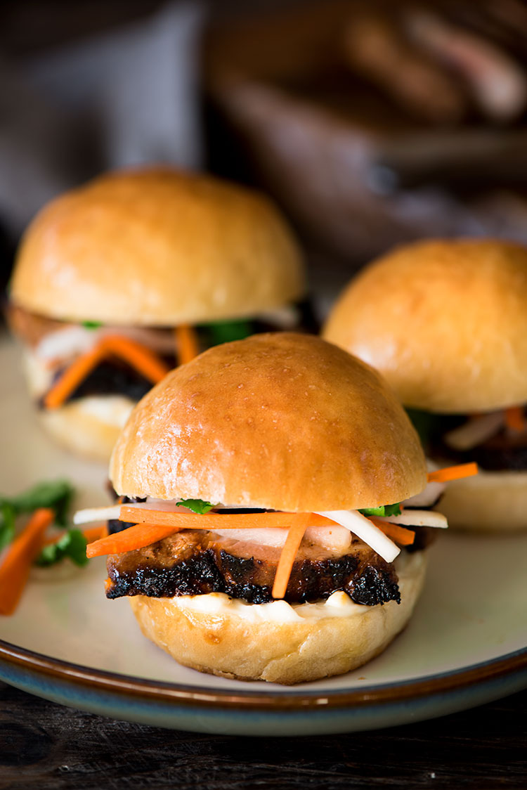 Juicy spicy, savory, sweet marinated pork beautifully charred, topped with sweet & sour pickled daikon & carrots between two heavenly soft, fluffy rolls.