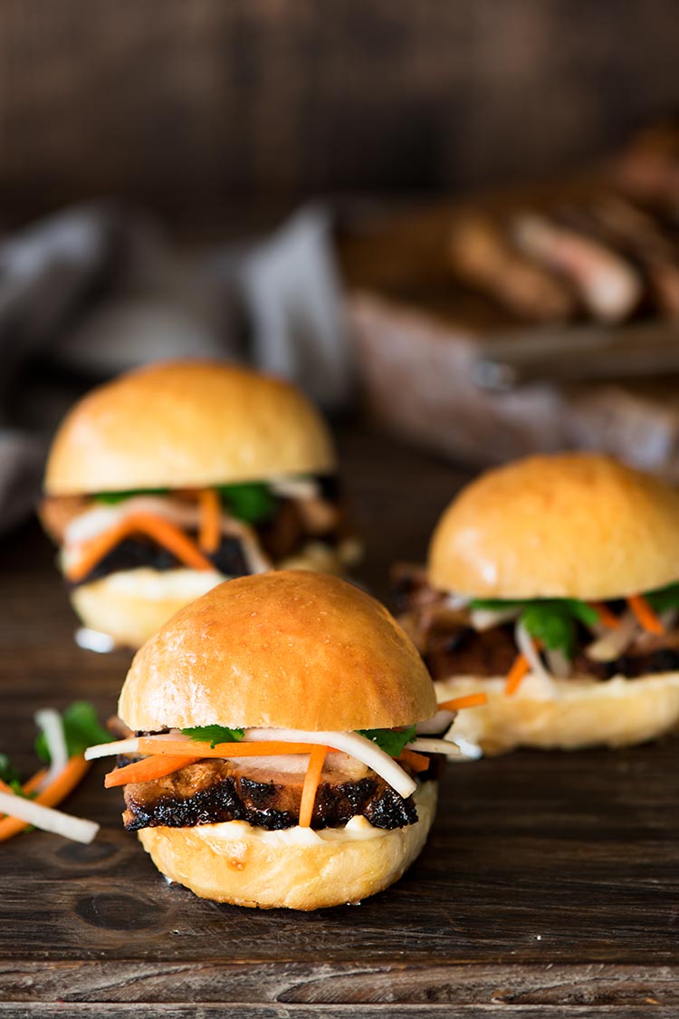 Juicy spicy, savory, sweet marinated pork beautifully charred, topped with sweet & sour pickled daikon & carrots between two heavenly soft, fluffy rolls.