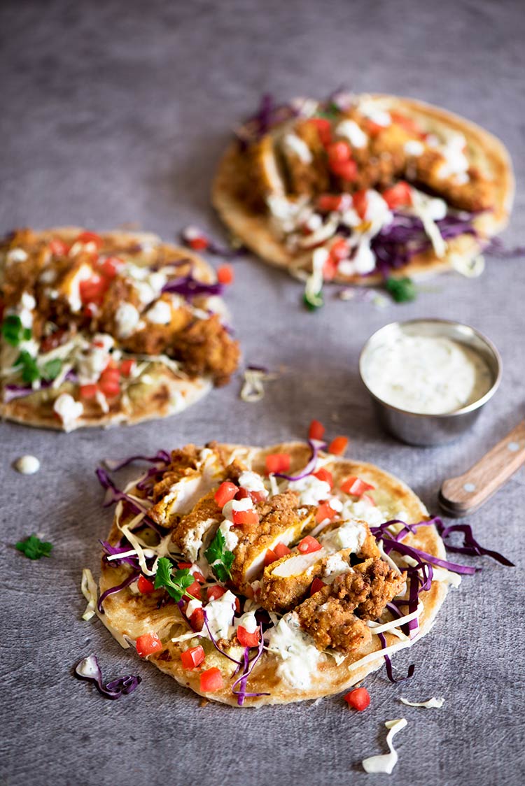 Uber crispy outside, moist and tender inside spiced fried chicken tenders with tomatillo chutney, cucumber mint raita all wrapped in flaky, crispy roti paratha.