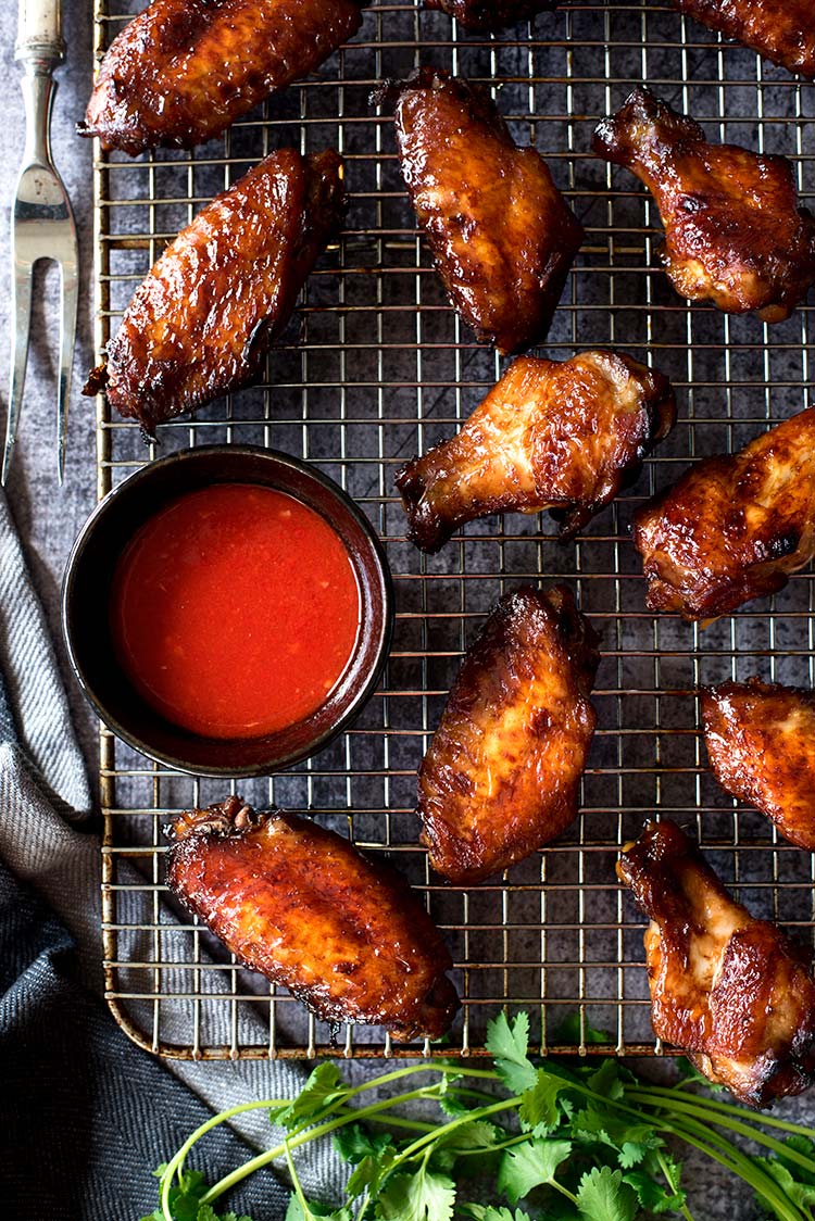 Smoky savory BBQ chicken wings with a tangy spicy chili sauce. Grilled or roasted in the oven, these wing-asm in your mouth wings are perfect for summer.