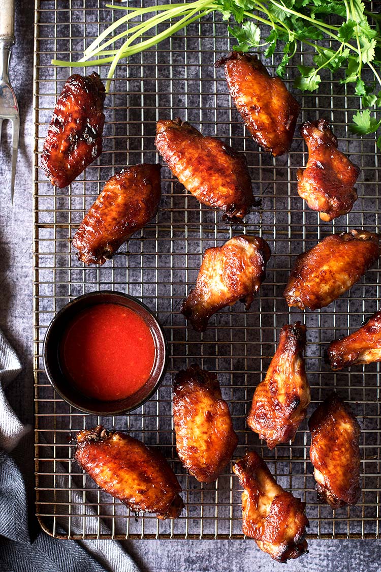 Smoky savory BBQ chicken wings with a tangy spicy chili sauce. Grilled or roasted in the oven, these wing-asm in your mouth wings are perfect for summer.