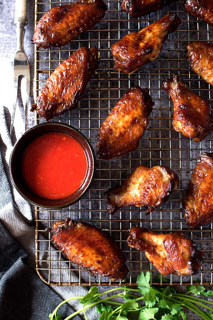 Smoky savory BBQ chicken wings with a tangy spicy chili sauce. Grilled or roasted in the oven, these wing-asm in your mouth wings are perfect for summer.